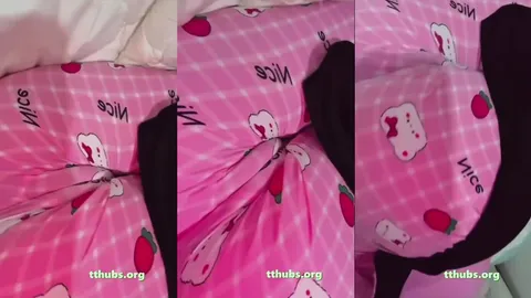 pembe pijamalı kadın yatakta yüzüstü yatıp kalçasını kıvırıyor