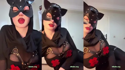 Türbanlı kadın kedi maskesiyle kameraya bakıyor