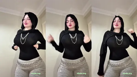 Türbanlı kadın siyah bluzla odada dans edip poz veriyor
