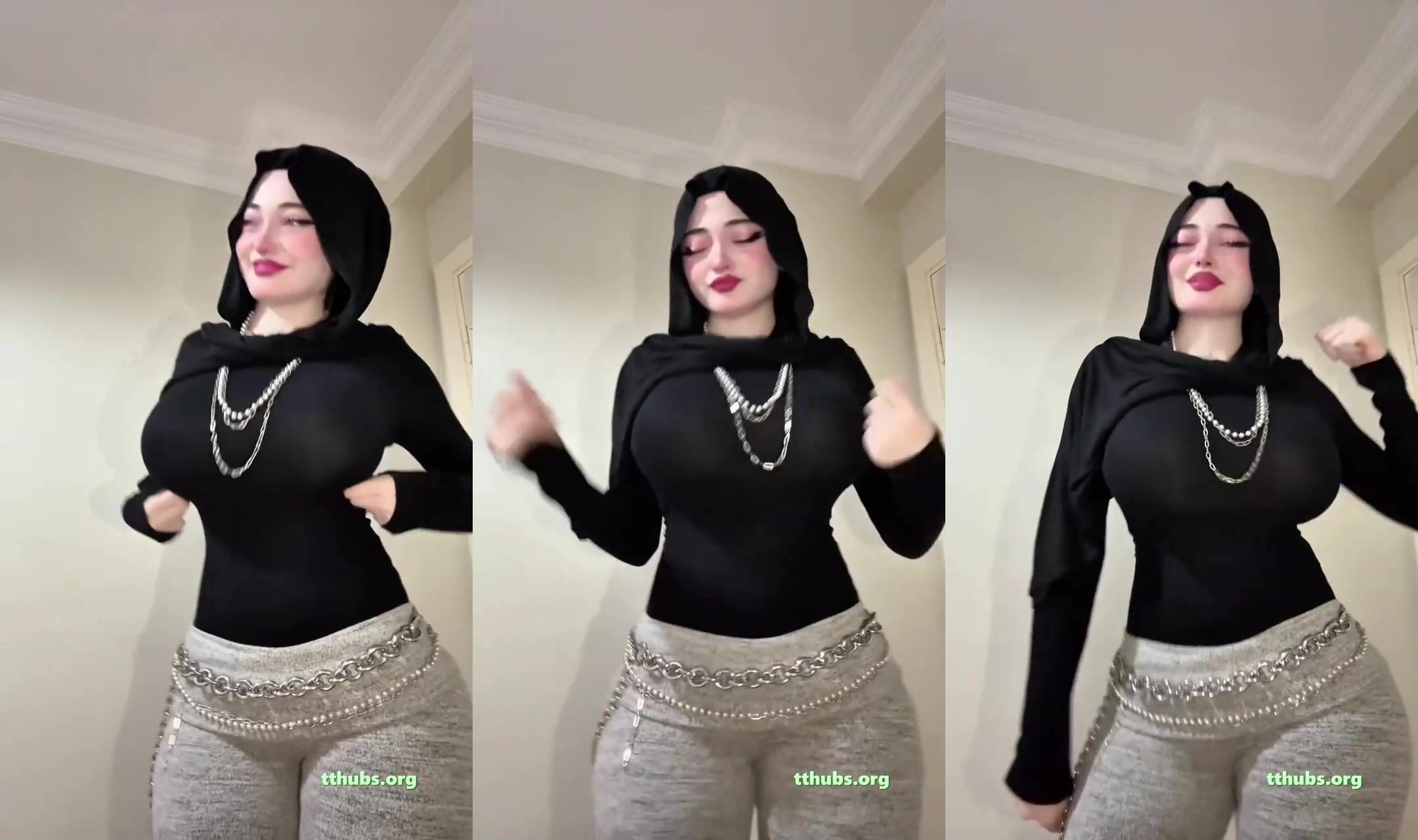 Türbanlı kadın siyah bluzla odada dans edip poz veriyor