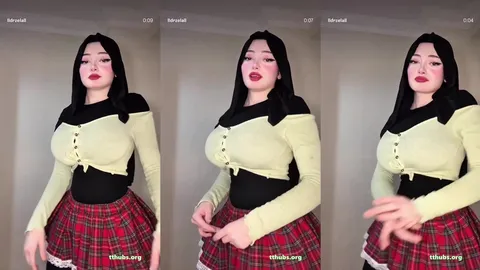 Dans eden siyah saçlı kadın krem bluz ve kırmızı ekose etekte